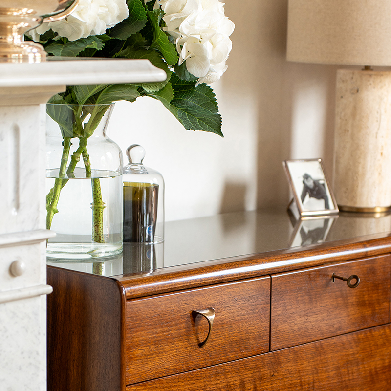 Adler Chest of Drawers in a room setting, in Walnut Dark French Polish finish with Antique Brass handle